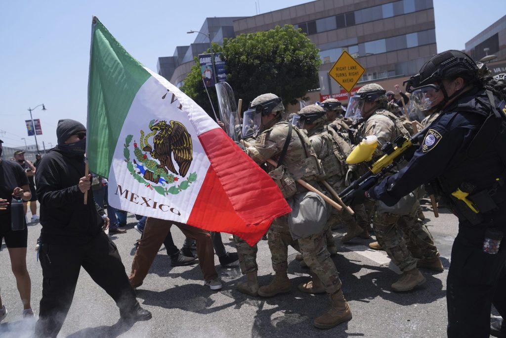 Manifestantes se enfrentan con las autoridades en el centro de Los Ángeles, el domingo 8 de junio de 2025, tras las protestas contra las redadas migratorias de la noche anterior. (AP Foto/Jae Hong, Archivo)