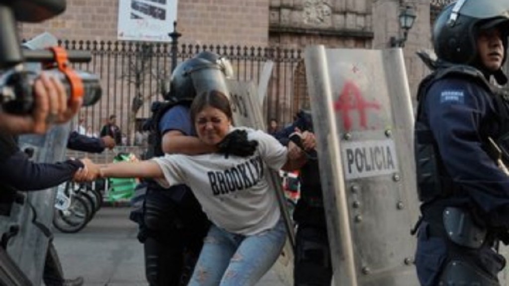 Una joven que protestaba frente al Palacio de Gobierno de Morelia, por el crimen del alcalde de Uruapan, es detenida al igual que otros manifestantes, algunos de los cuales irrumpieron en el recinto y causaron destrozos