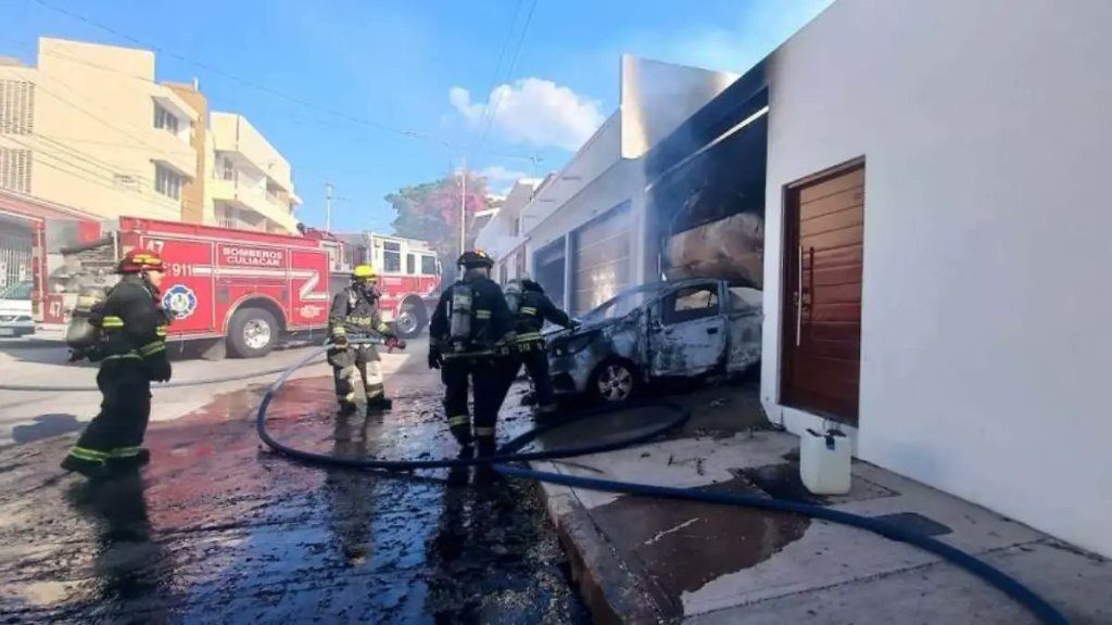 Bomberos y policías llegan a la residencia afectada en Lomas de Guadalupe para controlar el incendio y resguardar la zona.