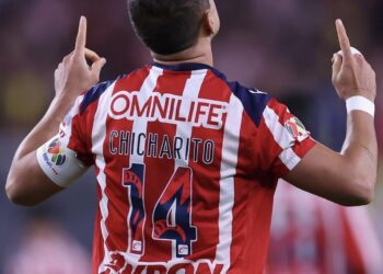 Fin de una Era: Javier 'Chicharito' Hernández Deja de Formar Parte de las Chivas El Club Deportivo Guadalajara, una de las instituciones más emblemáticas del fútbol mexicano, ha confirmado una noticia que marca el fin de un ciclo: Javier 'Chicharito' Hernández ha dejado de formar parte del equipo. El anuncio oficial fue realizado por la directiva del Club Chivas, poniendo punto final a la segunda etapa del delantero con el equipo que lo vio nacer como profesional en la Liga MX. La salida del 'Chicharito' del Club Chivas se da después de su regreso triunfal al equipo en enero de 2024, un evento que generó una enorme expectativa entre la afición. Su retorno fue considerado como un momento histórico, ya que el atacante había desarrollado una exitosa carrera internacional en clubes de la talla del Manchester United y el Real Madrid. Sin embargo, su desempeño en esta segunda etapa estuvo marcado por la lucha contra las lesiones y un rendimiento intermitente. El Desafío de su Segunda Etapa en Chivas La segunda aventura de 'Chicharito' con las Chivas estuvo plagada de retos, principalmente derivados de la grave lesión de ligamento cruzado anterior que sufrió antes de su reincorporación al equipo. Aunque demostró compromiso y esfuerzo por recuperar su nivel, la falta de ritmo y los problemas físicos impidieron que el delantero pudiera ofrecer la versión goleadora que los aficionados y la directiva esperaban. A pesar de las dificultades, la presencia de Javier Hernández en el vestuario de Chivas siempre fue valorada por el liderazgo y la experiencia que aportaba a los jugadores más jóvenes. No obstante, el alto costo de su contrato y la necesidad del club de liberar espacio salarial para futuras contrataciones, sumados a la irregularidad en la cancha, llevaron a la directiva a tomar la difícil decisión de no renovar el vínculo contractual con el histórico jugador. El Legado de 'Chicharito' y la Búsqueda de Nuevos Horizontes La partida del 'Chicharito' de las Chivas no borra el impacto que tuvo en su primera etapa y el significado emocional de su regreso. El delantero siempre será recordado como un producto genuino de la cantera rojiblanca, cuya exitosa carrera en Europa elevó el perfil del fútbol mexicano a nivel global. Su legado en el equipo de Guadalajara es indiscutible y siempre estará ligado a la historia reciente del club. Como valor agregado, esta salida abre de manera notable el mercado para Javier Hernández. Ahora como agente libre, el 'Chicharito' tiene la oportunidad de negociar con cualquier club sin la restricción de un traspaso, un hecho que podría atraer el interés de equipos de la MLS o incluso de ligas de menor exigencia en Europa o de vuelta en la Liga MX. La decisión sobre su próximo destino será crucial para determinar el capítulo final de su carrera, lejos de las Chivas. La afición de las Chivas, aunque triste por la despedida, reconoce la trayectoria y el esfuerzo del jugador. Ahora, el Club Deportivo Guadalajara se enfoca en el futuro, buscando refuerzos que puedan llenar el vacío en la delantera y continuar con la tradición de ser un equipo protagonista en el fútbol mexicano, cerrando el capítulo del 'Chicharito' para dar paso a una nueva etapa.