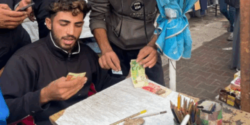 Escasez de Dinero en Gaza Impulsa el Auge de un Nuevo Negocio: la Reparación de Billetes