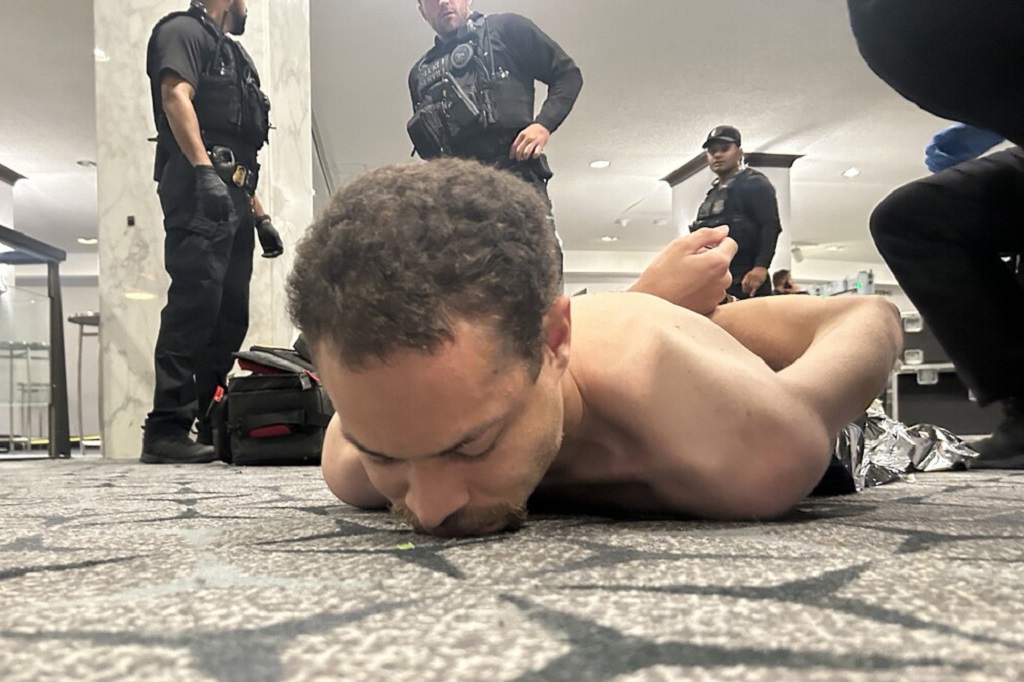 Fotografía difundida en la cuenta oficial @realDonaldTrump de la red social Truth, del presidente de los Estados Unidos, Donald Trump, donde se muestra al supuesto tirador arrestado por agentes del Servicio Secreto, luego de que se reportaran disparos durante la Cena de Corresponsales de la Casa Blanca (EFE)