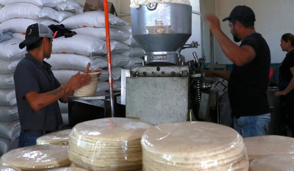 Trabajadores de un molino producen tortillas en la Ciudad de México, mientras que el CNT advirtió que es insostenible no subir el precio actual