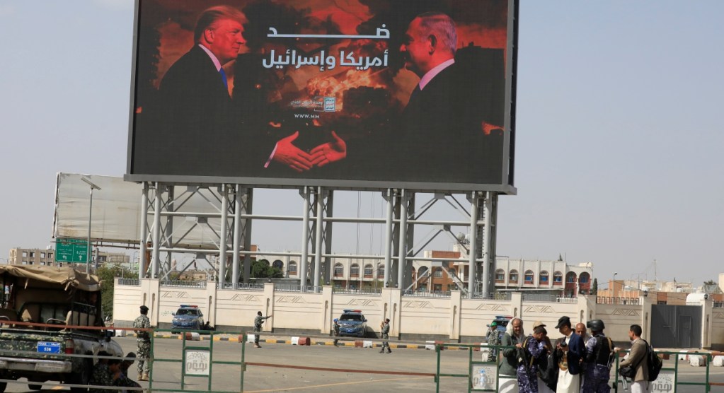 Soldados hutíes custodian una valla con imágenes de Donald Trump y Benjamin Netanyahu. Analistas republicanos critican políticas bélicas