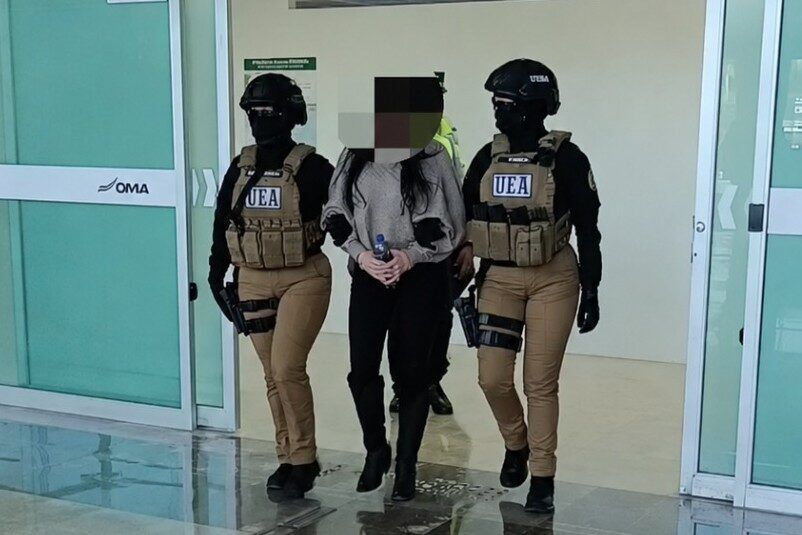 Elementos de seguridad trasladan a una mujer detenida por su presunta participación en un secuestro ocurrido en Culiacán en 2016. La acusada fue localizada en Puebla y quedó bajo prisión preventiva.